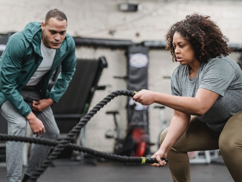 Two people are using ropes to work out.